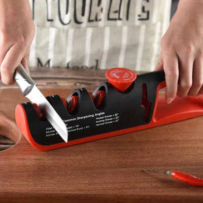 aiguiseur de couteaux manuel tenu à deux mains sur un plan de travail