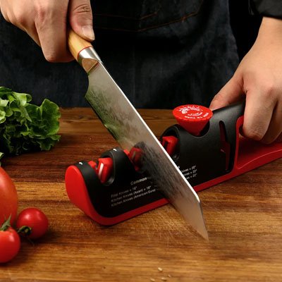 aiguiseur de couteaux rouge utilisé sur un plan de travail en bois