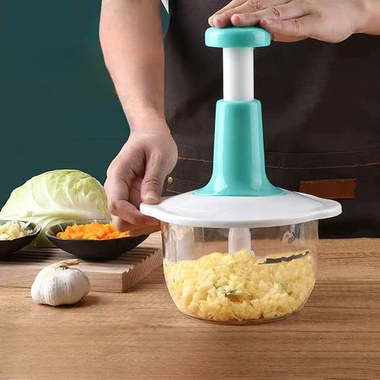 Hachoir manuel à pression avec ail et chou sur une planche en bois