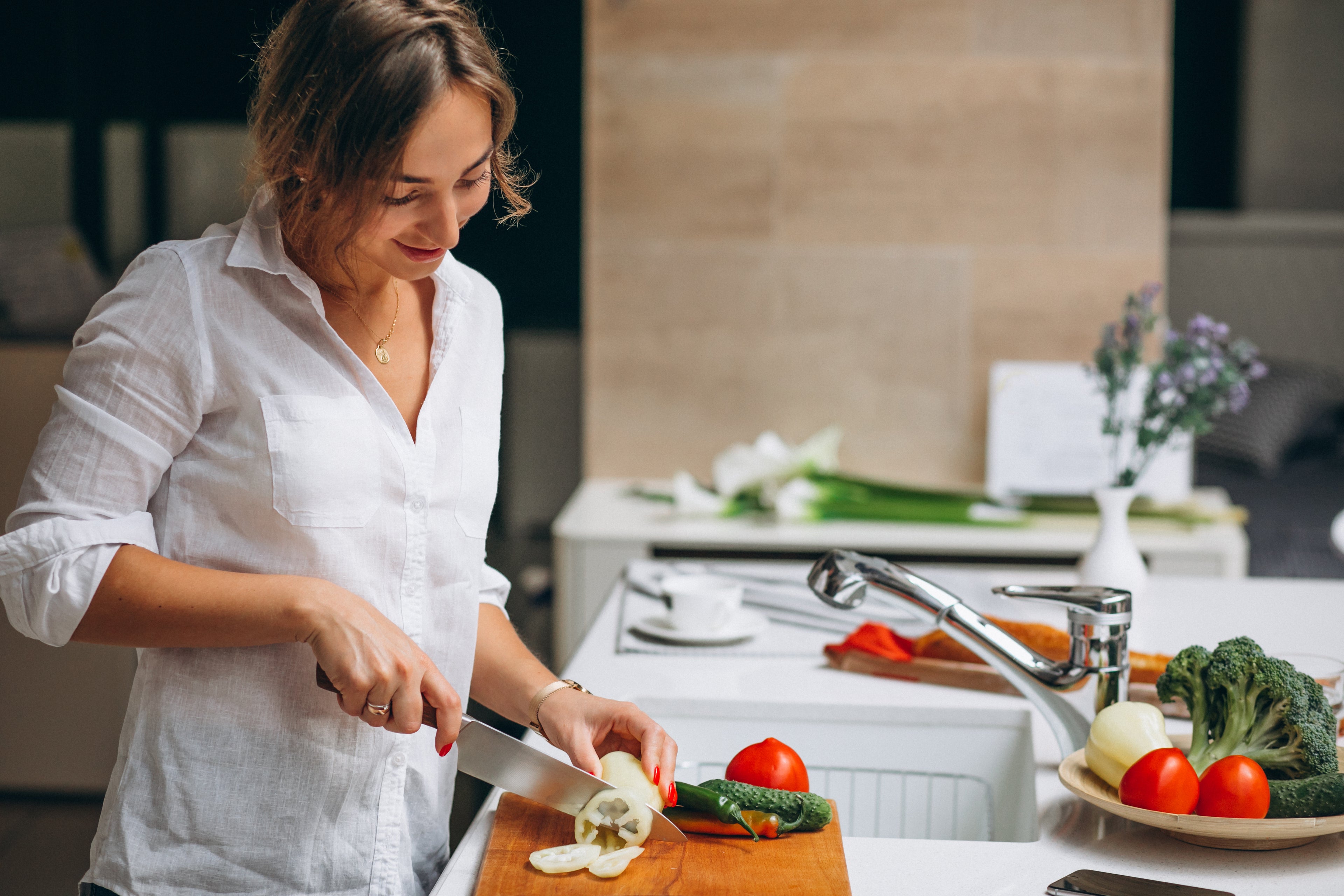 jeune femme cuisine qui coupe des légumes